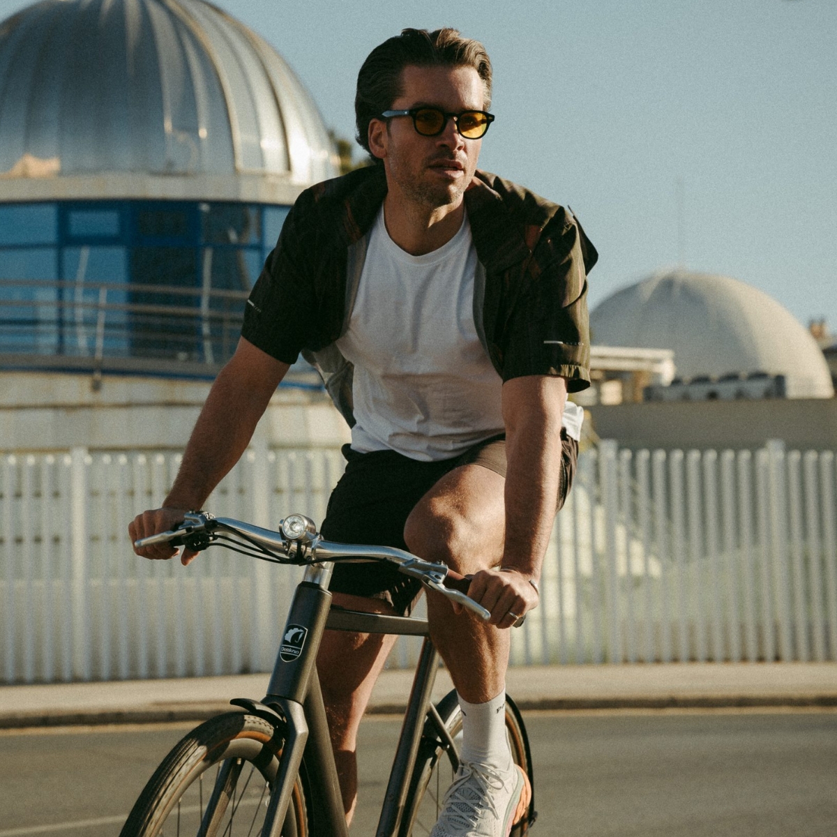 Mann auf Desiknio-Bike vor moderner Kulisse.